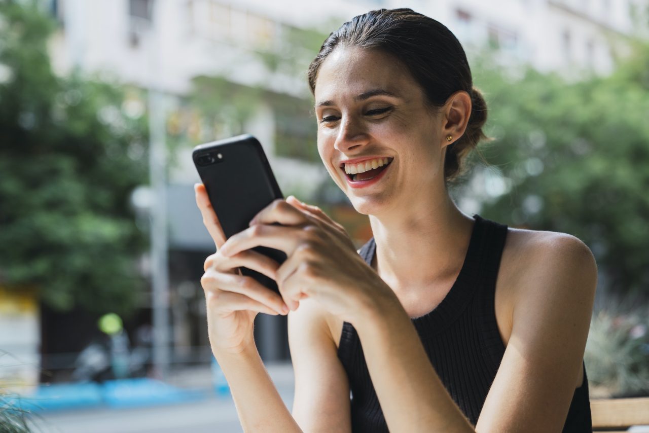 young woman sitting in cofee shop using smartphone